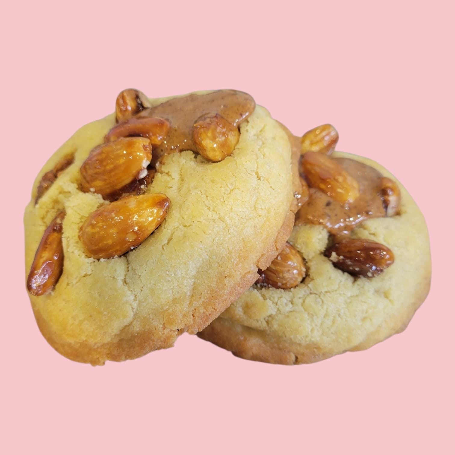 Deux cookies fourré praliné avec des amandes caramélisées dessus, empilés l'un sur l'autre