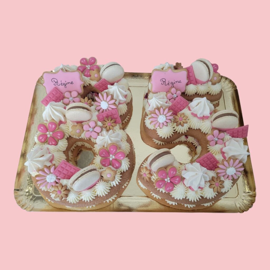 number cake 85 dans des tons de couleur rose poudré et blanc, avec des fleurs en biscuits décorés en glaçage