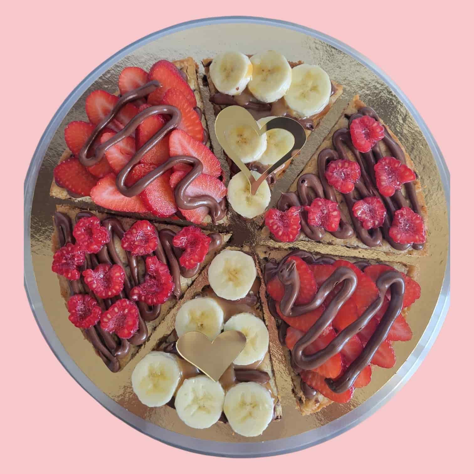 cookies géant partagé en six parts décorés différemment avec fraises, framboise, nutella, banane